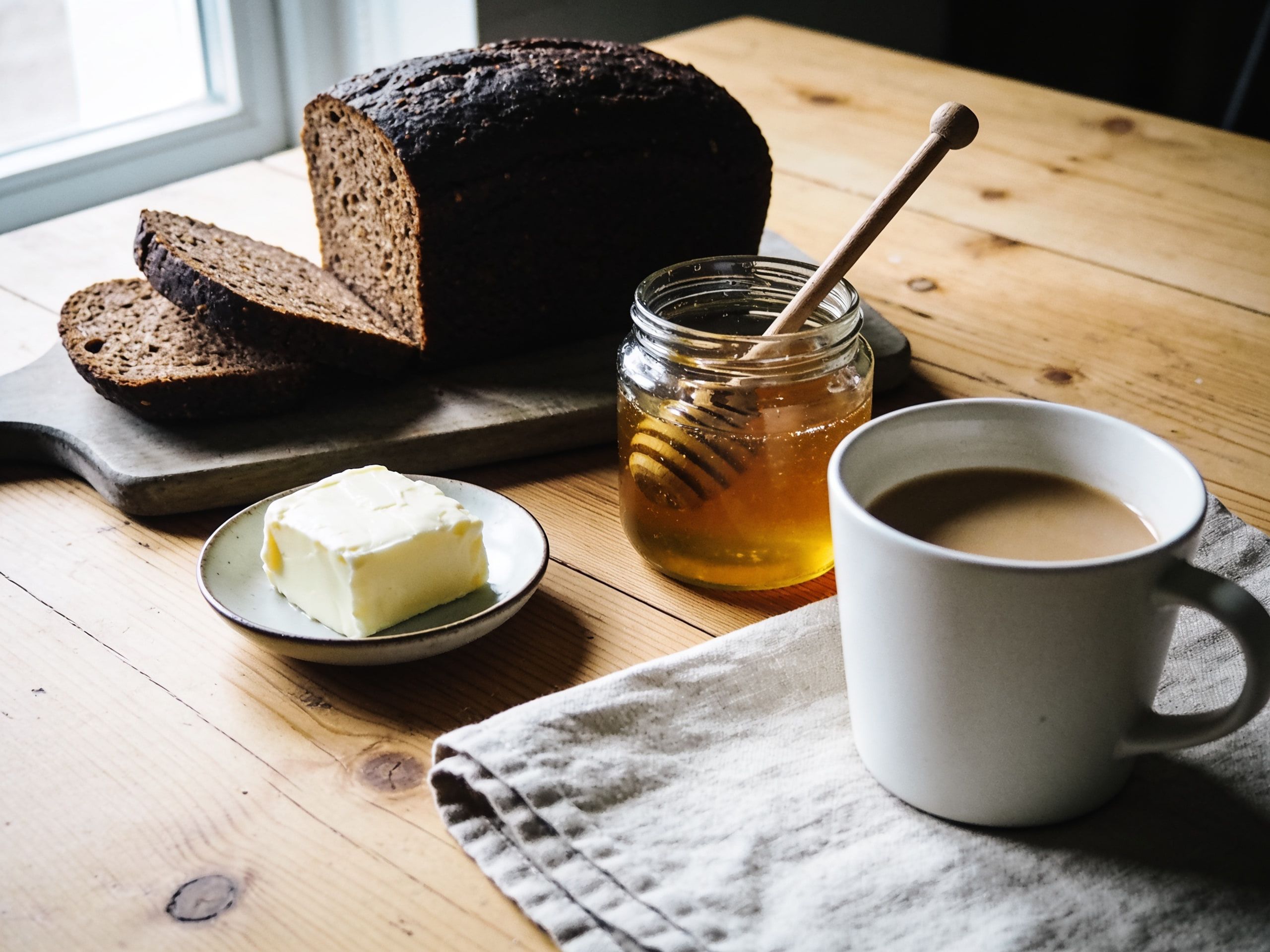 Frühstück: Brot, Butter und Berghonig auf Lärchenholz